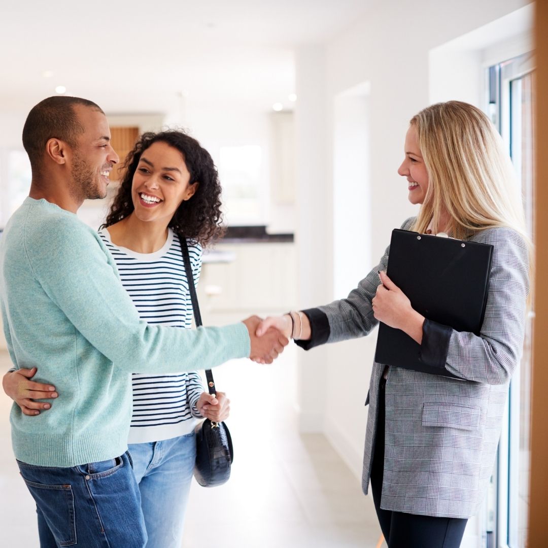 Couple shaking hands with realtor