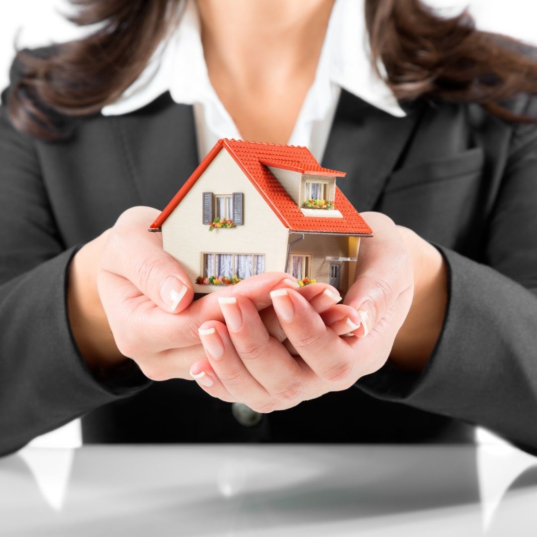 Woman holding small house