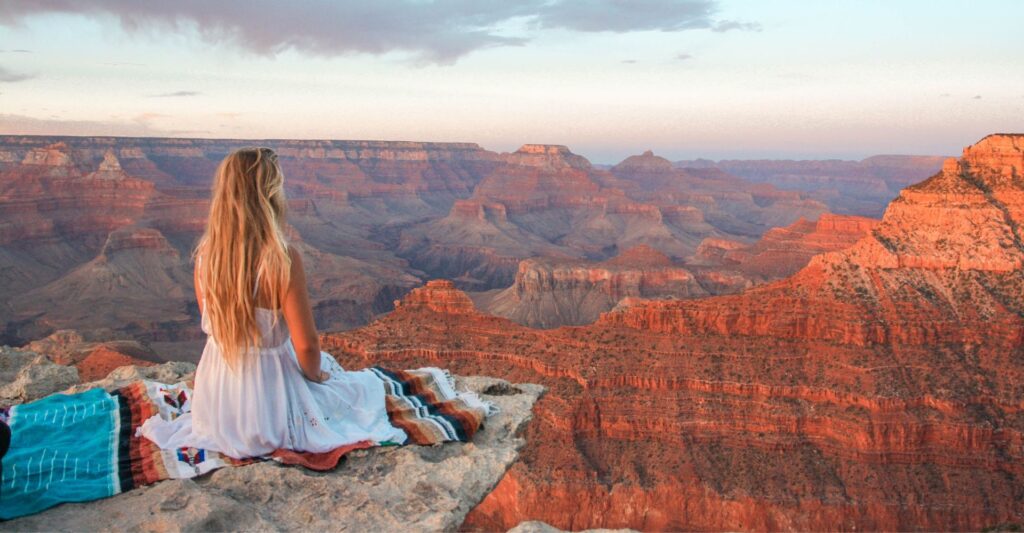 woman sitting in front of the grand canyon