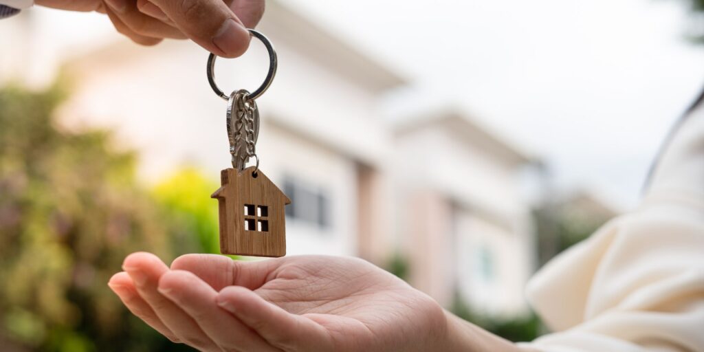 Person handing someone a house key
